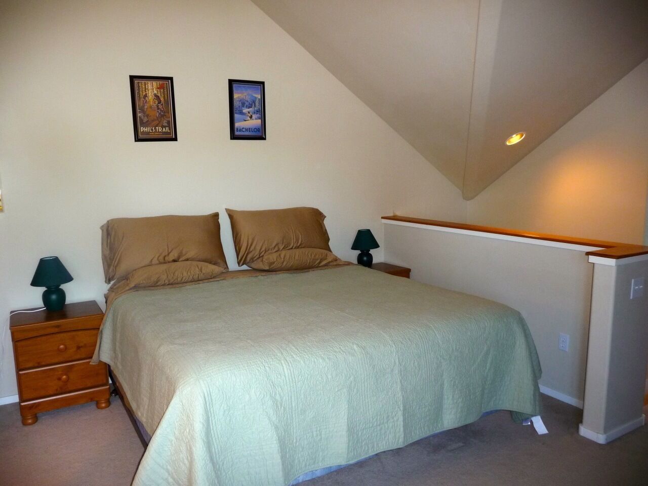 Ein Schlafzimmer mit einem Bett, zwei Nachttischen, einer Lampe und einem Kühlschrank.