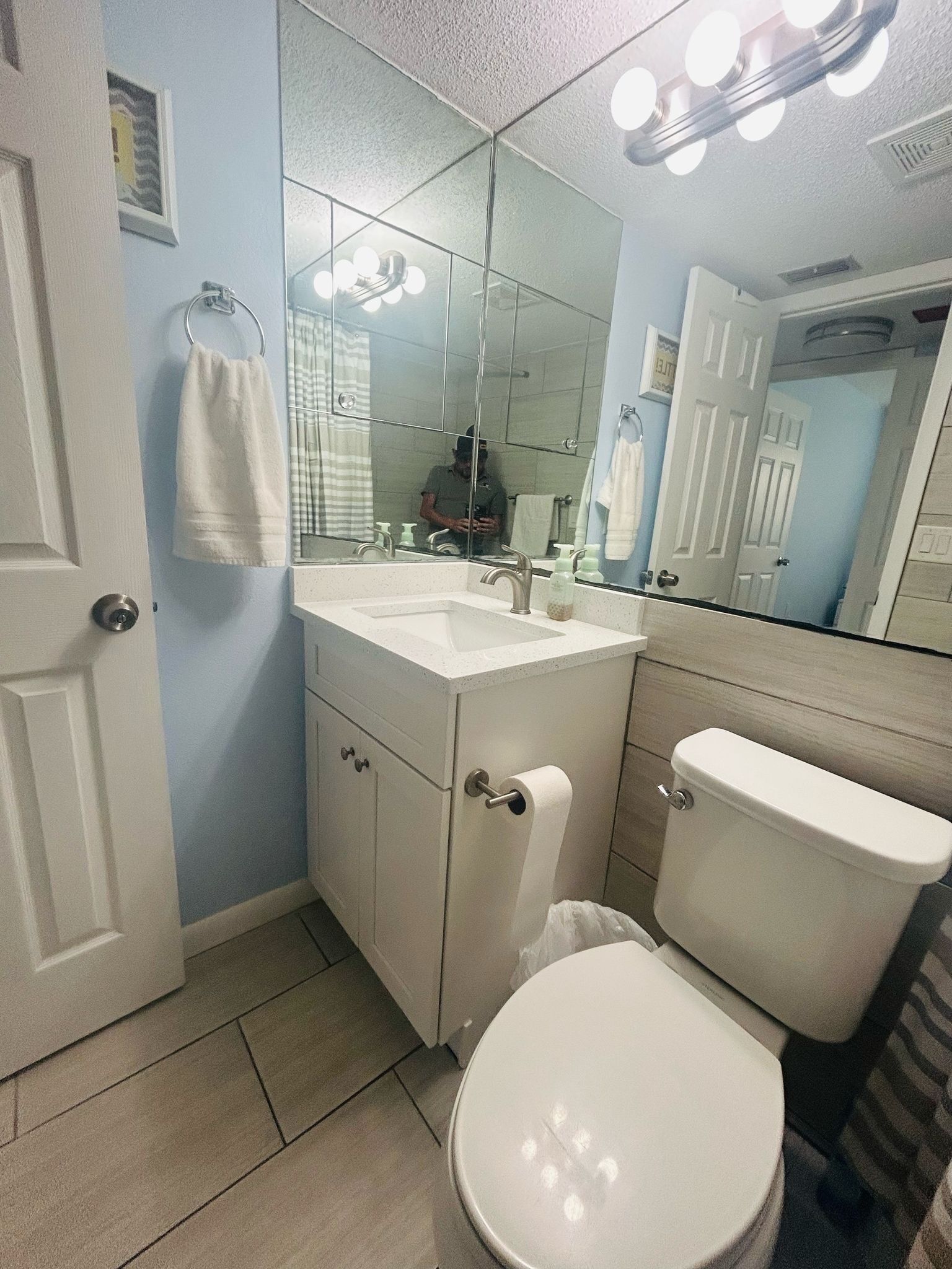 Une salle de bain avec des toilettes, un lavabo et un miroir.