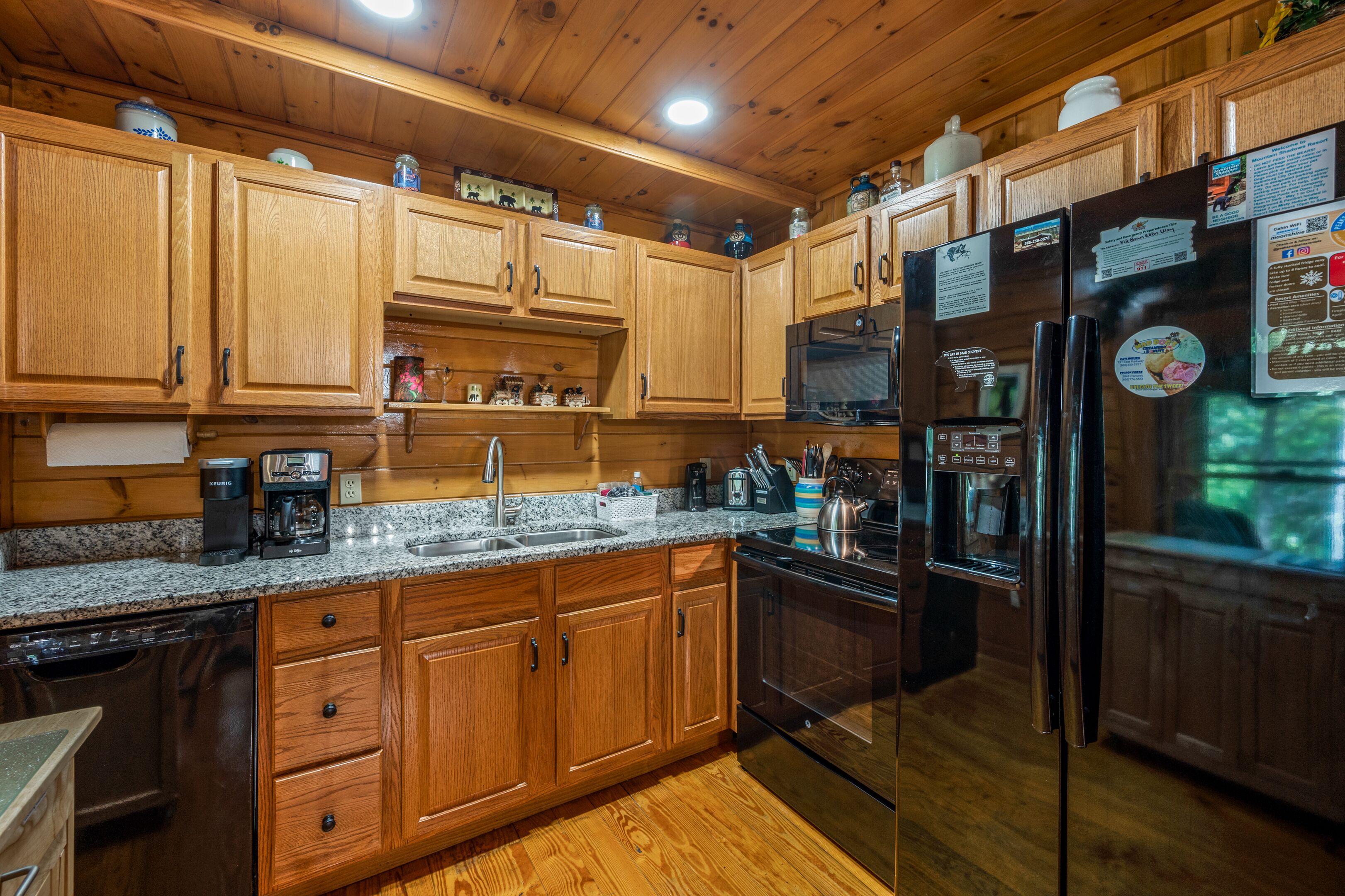 A kitchen with wooden cabinets, granite countertops, stainless steel appliances, and a built-in oven.