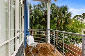 Relax on the deck overlooking a serene garden with lush tropical plants.