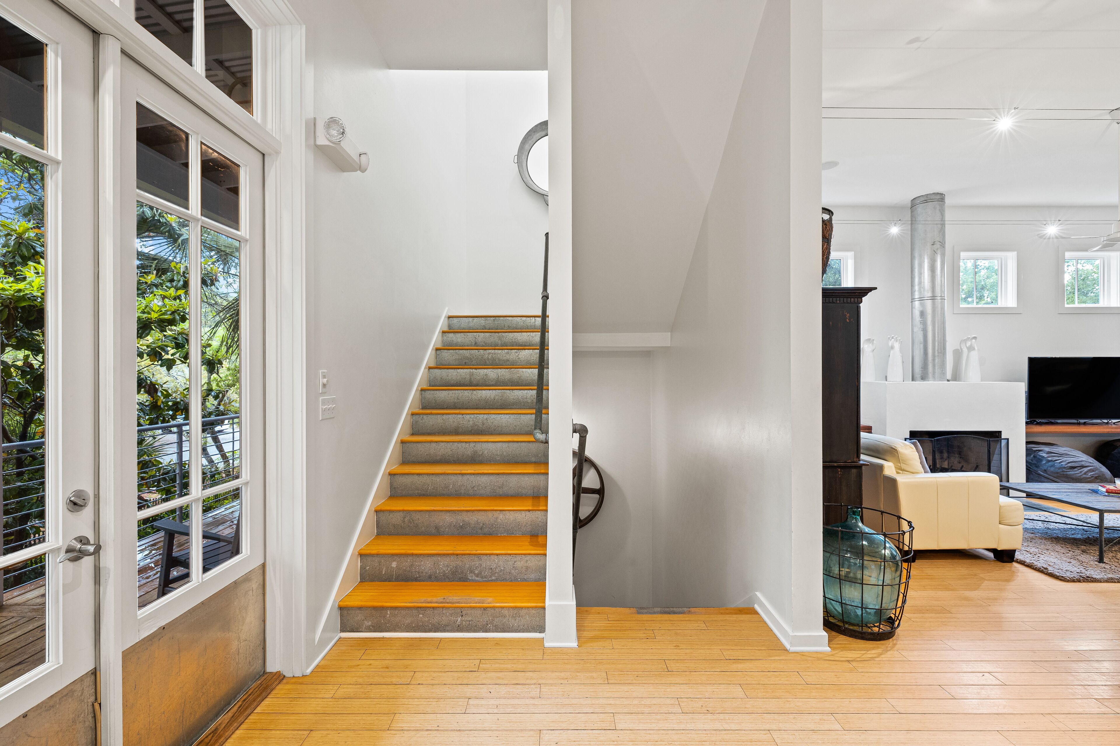 A staircase leading to a living area with a fireplace, a sofa, and a television.