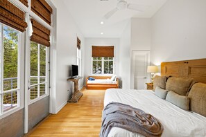 Relax in this serene bedroom with a large bed, TV, and comfortable nightstand.