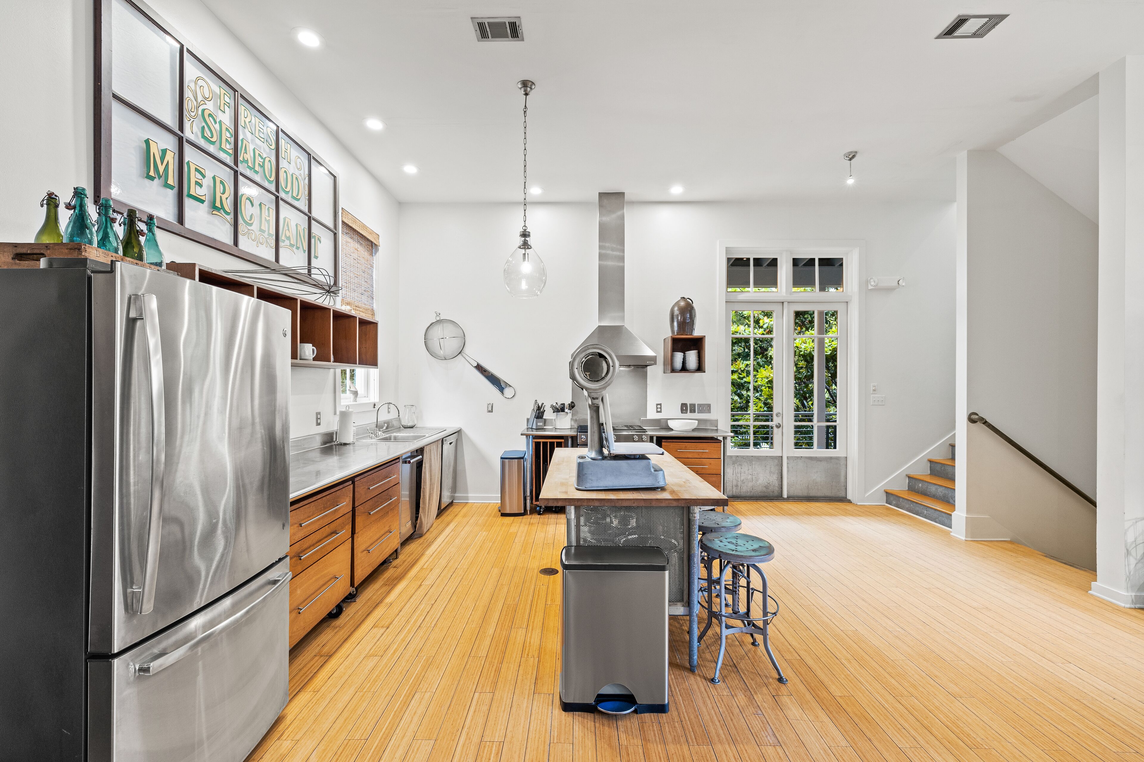 A modern kitchen with stainless steel appliances, wooden cabinets, and a central island.