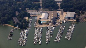 An aerial view of a marina with numerous boats docked, surrounded by trees and buildings. - The Staterooms 2J, Directions, Newly Built, Seasonally Heated Pool, Beach Nearby (Holland)
