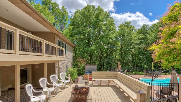 Terraza con mobiliario exterior, una chimenea y una piscina.