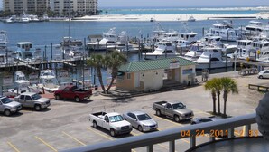 A marina with boats docked, a small building, and a parking area with vehicles. - DESTIN HARBORWALK, 3 bedrooms w/ Boatdock (destin)