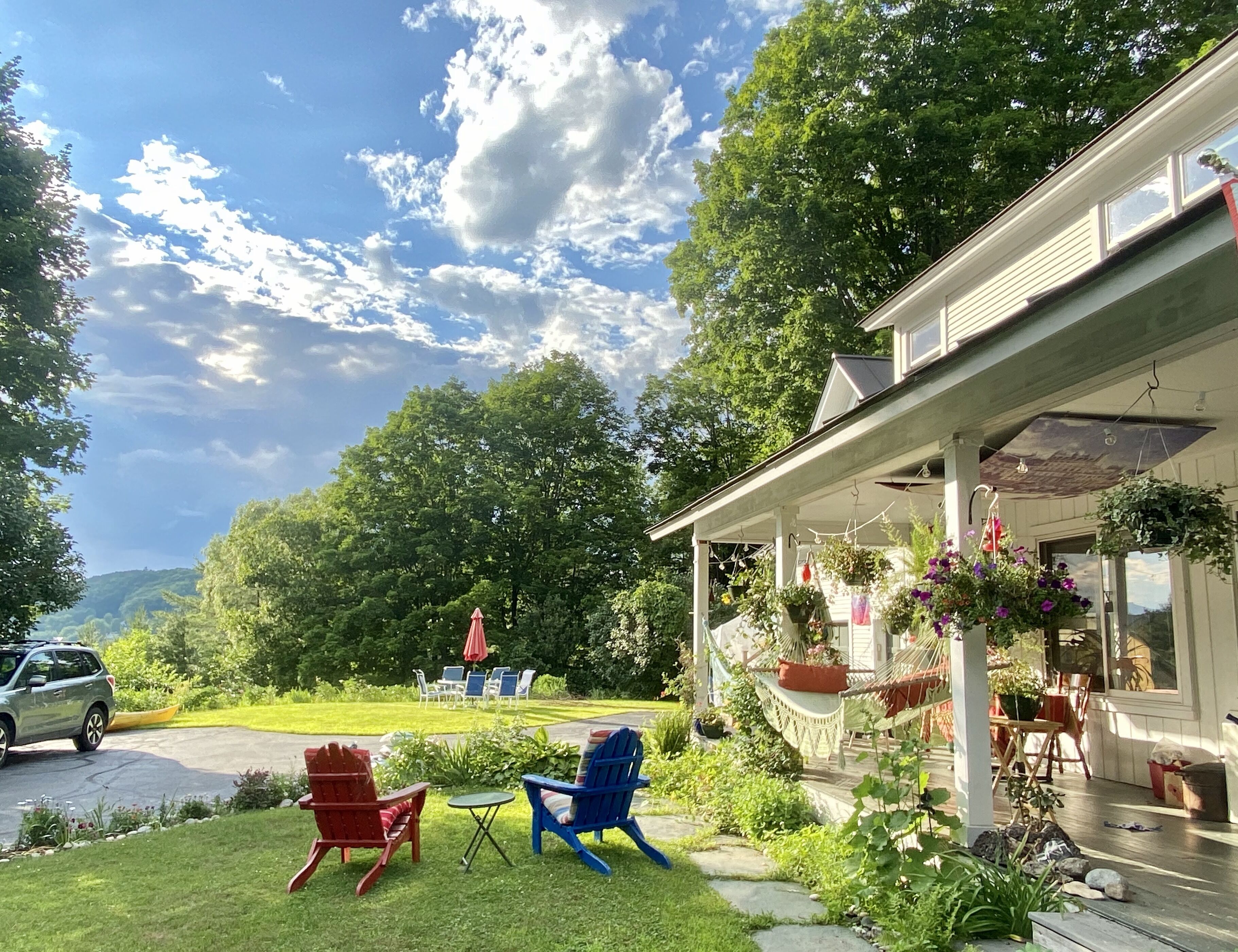 A house with a porch, outdoor seating, and a garden.