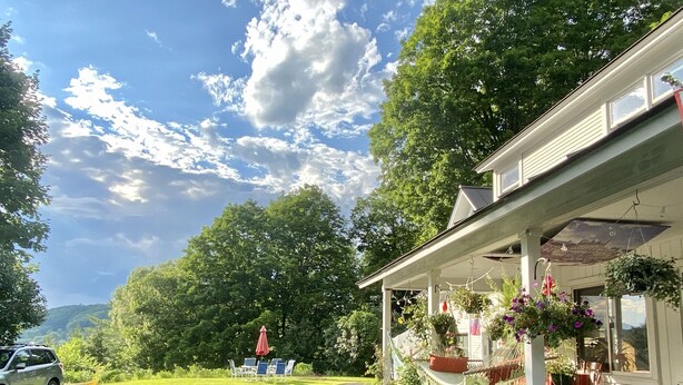 Et hus med en veranda, udendørs møbler og en have.