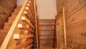 Una escalera de madera con un rellano alfombrado.