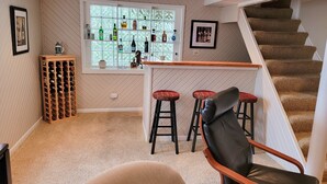 A cozy interior with a bar area, a staircase, and a seating area. - 
Luxe  Fully Furnished 5 Star Home in Hyde Park/ Cincinnati (Cincinnati)