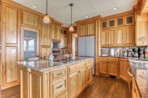 Enjoy cooking in this well-equipped kitchen with a large island, appliances, and a coffee station.