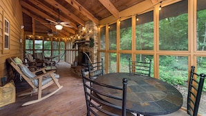 A wooden cabin with a stone fireplace, large windows, and a round table with chairs. - Mentone “Rest Easy” - Tranquil Serenity & Pet Friendly (Mentone)