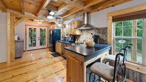 A spacious kitchen with wooden beams, a large island, and a view of the outdoors. - Mentone “Rest Easy” - Tranquil Serenity & Pet Friendly (Mentone)