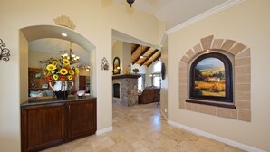 A spacious interior with a stone fireplace, a dining area, and a kitchen with wooden cabinets.