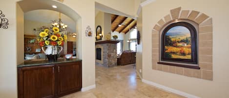A spacious interior with a stone fireplace, a dining area, and a kitchen with wooden cabinets.