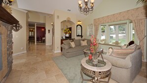 A spacious living room with a fireplace, a dining area, and a view of the outdoors.