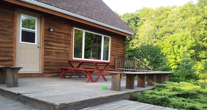 Location de chalet dans les bois pittoresques du Maine avec des sentiers de raquette et une cheminée.