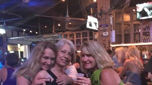 A bar with wooden furniture and hanging lights. - 3rd floor, Right on the Beach! Cozy, Comfy, & a Stunning View! Near Pier Park! (Panama City Beach)