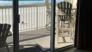 A balcony with a view of the ocean, featuring two Adirondack chairs and a small table. - 3rd floor, Right on the Beach! Cozy, Comfy, & a Stunning View! Near Pier Park! (Panama City Beach)