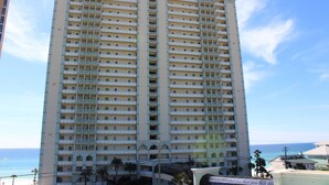 A high-rise hotel with multiple balconies, a central atrium, and a view of the ocean. - 3rd floor, Right on the Beach! Cozy, Comfy, & a Stunning View! Near Pier Park! (Panama City Beach)