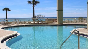 A swimming pool with a curved edge, a metal handrail, and lounge chairs along the poolside. - 3rd floor, Right on the Beach! Cozy, Comfy, & a Stunning View! Near Pier Park! (Panama City Beach)