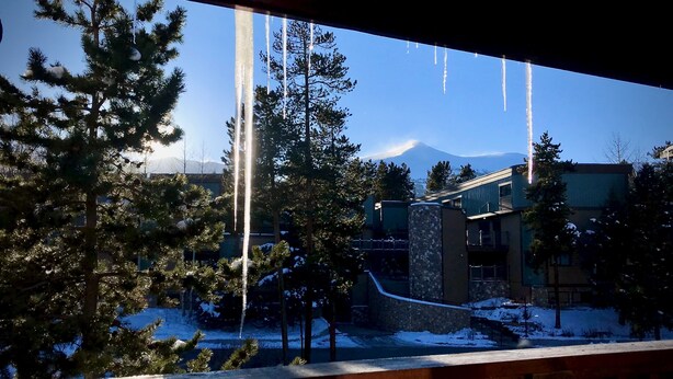 Vista de un edificio con paisaje nevado y una montaña al fondo.