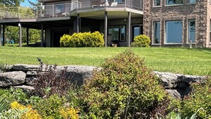 Een ruime woning met een overdekt terras en een gevel van natuursteen.