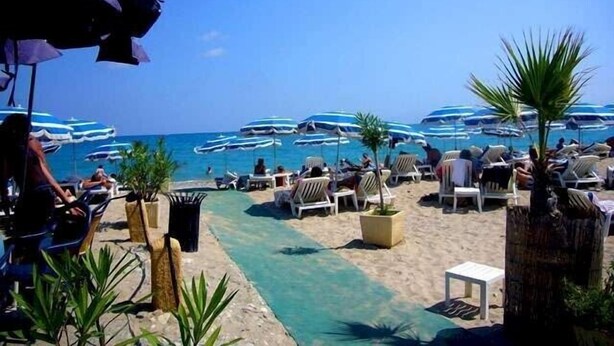 A beachside resort with lounge chairs and umbrellas, a clear pool, and boats in the background. - Charming Village House In Medieval Village, Close To Beach And Nice (Cagnes-Sur-Mer)