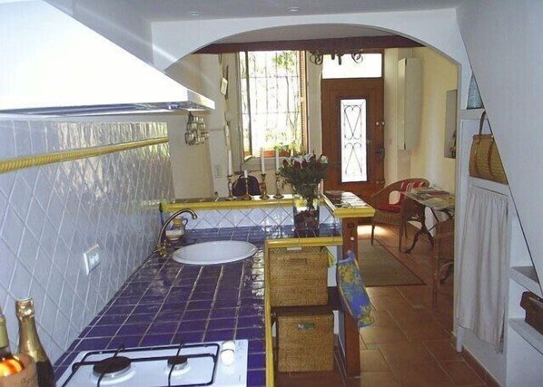 A kitchen with a gas stove, sink, and blue-tiled backsplash. - Charming Village House In Medieval Village, Close To Beach And Nice (Cagnes-Sur-Mer)