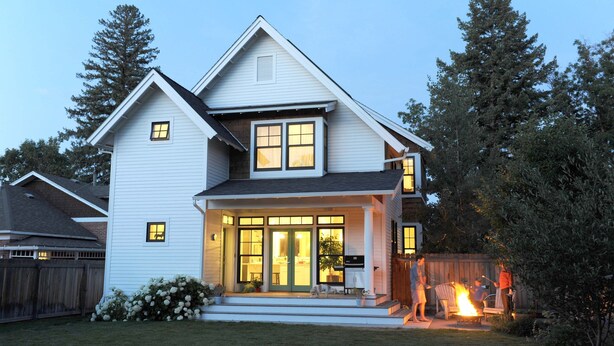 A two-story house with a front porch, a visible garage, and a backyard with a fire. - Modern Farmhouse in Historic Downtown Bozeman (Bozeman)