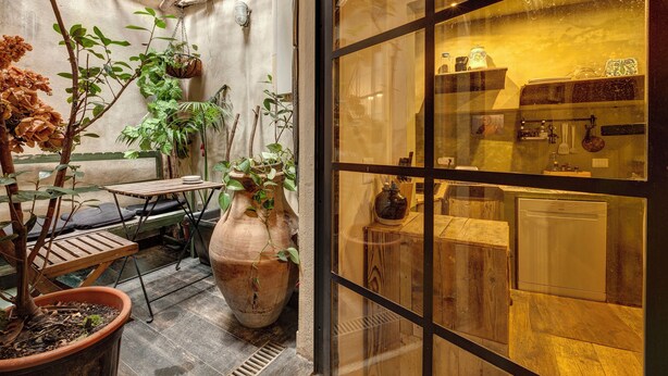 A cozy patio area with potted plants, a wooden table, and a large vase. - CHARMING HIDEAWAY IN FLORENCE OLD TOWN (Firenze)