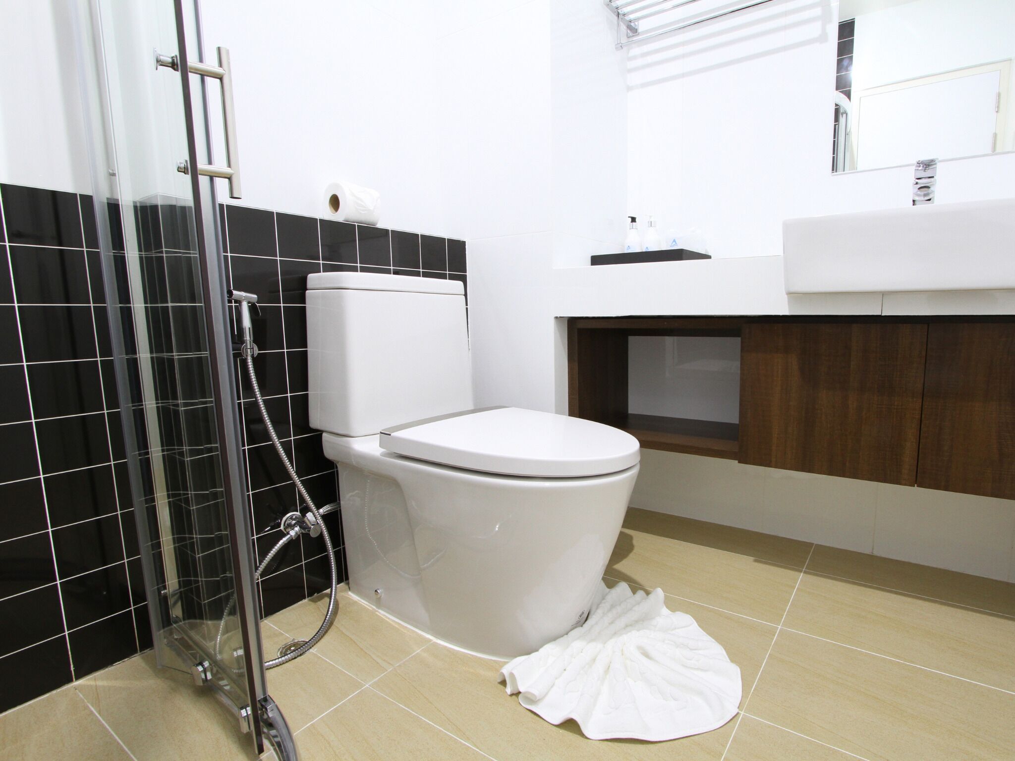 A bathroom with a toilet, shower, and sink.