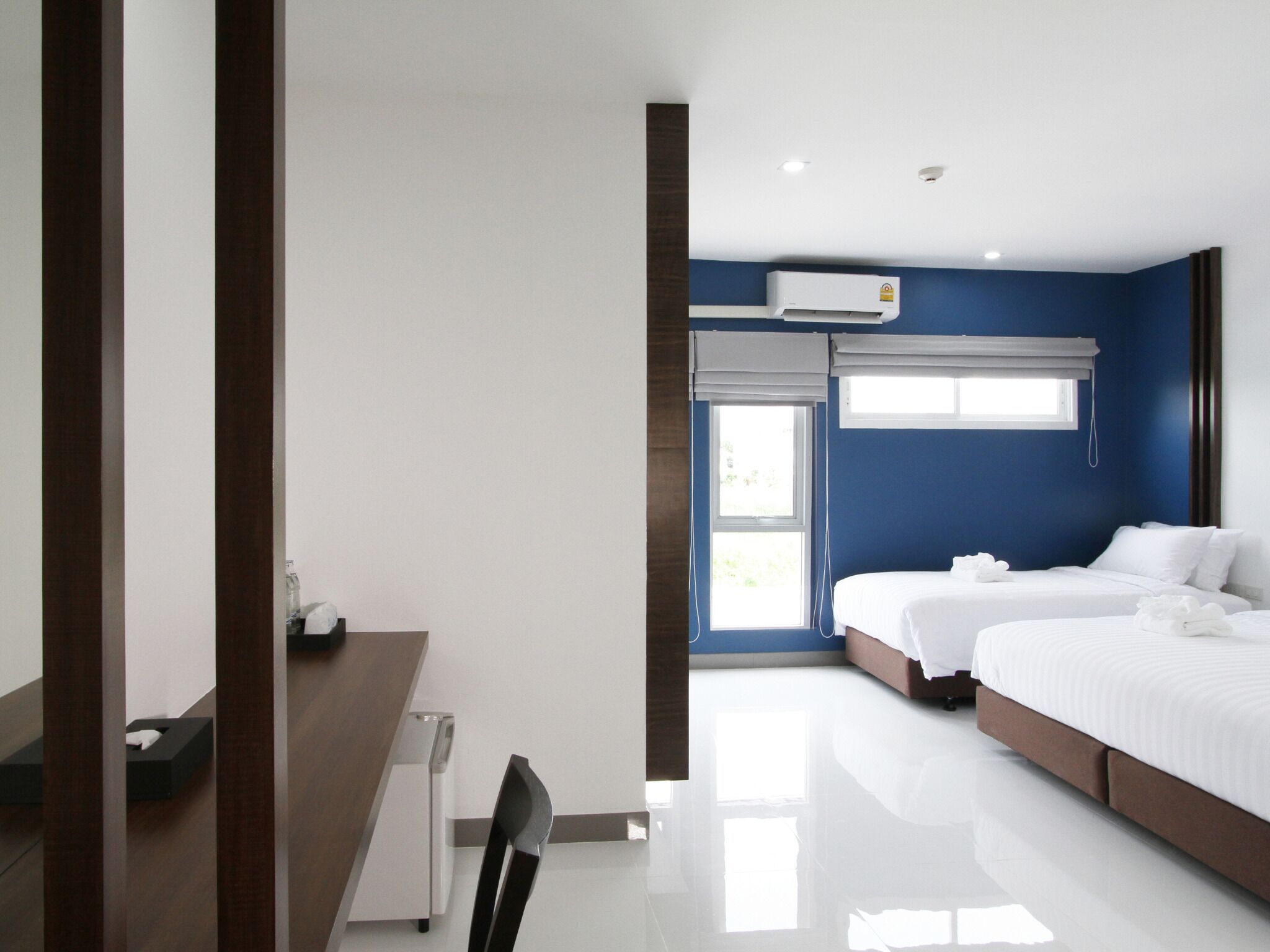 Una habitación de hotel moderna con una cama grande, un escritorio y un equipo de aire acondicionado.