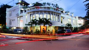 A hotel with a curved facade, multiple windows, and a sign indicating it is Hotel Mataram 2. - Hotel Mataram 2 Malioboro (Yogyakarta)