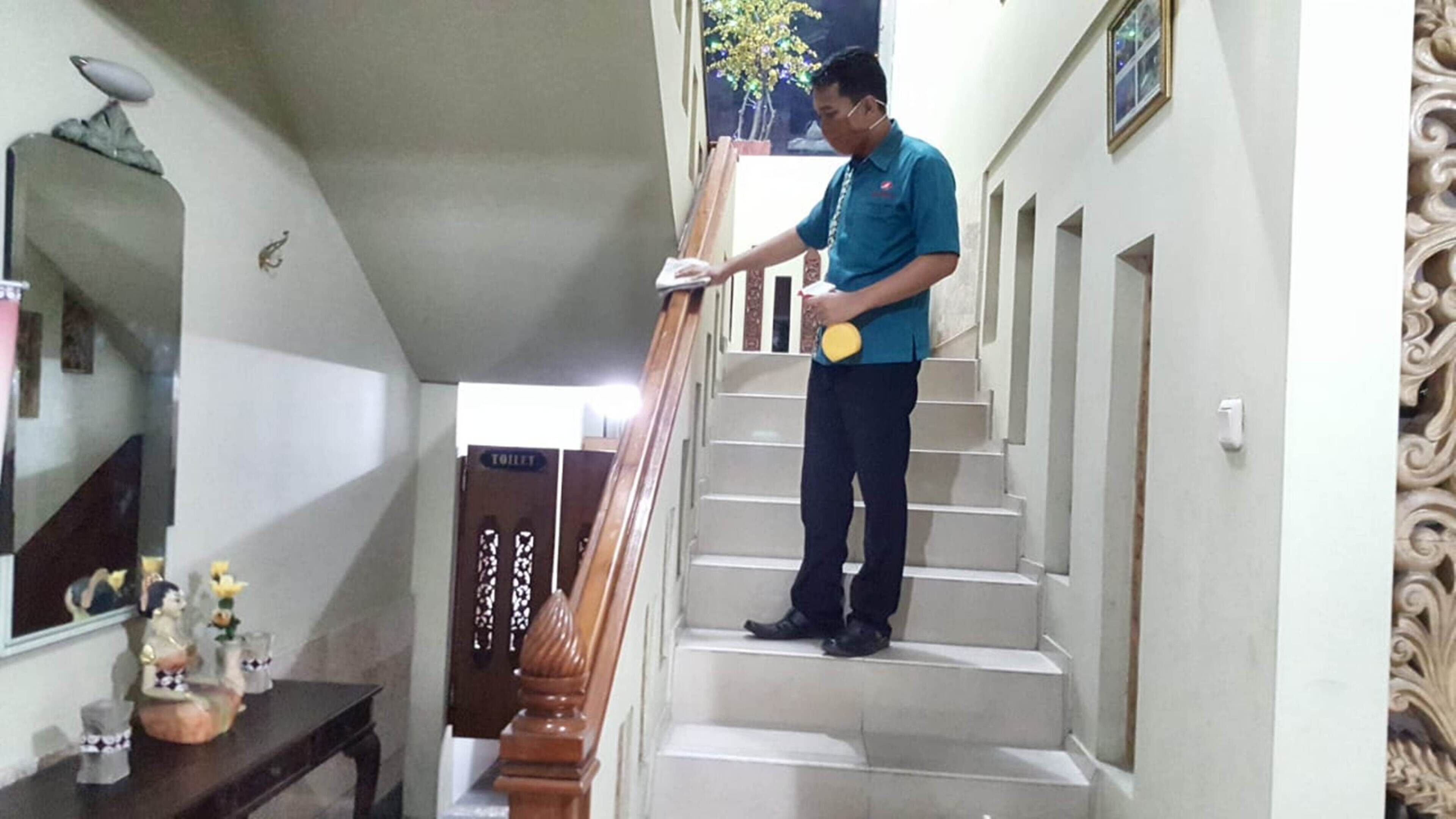 A person cleaning a staircase with a mop and bucket.