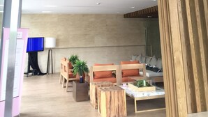 A modern interior with a wooden floor, a sofa set, a coffee table, and a plant.