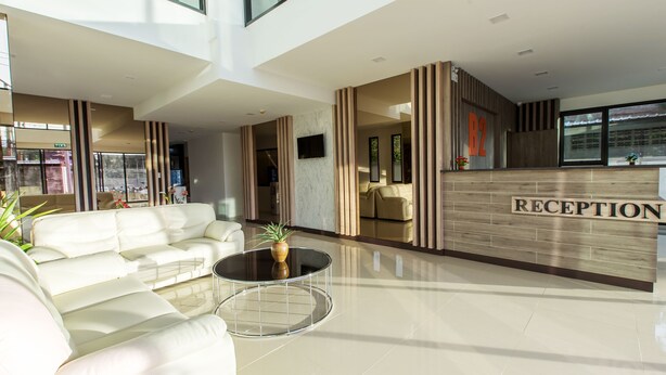 A modern reception area with a reception desk, a sofa, and a coffee table. - B2 Ubon Premier Hotel (Ubon Ratchathani)
