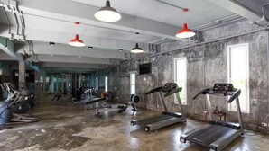 A gym with treadmills, stationary bikes, and weight machines. - Condo Studio B at Replay E305 (Koh Samui)