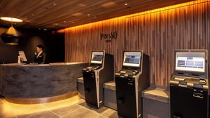 A reception area with a wooden wall, a reception desk, and three self-service kiosks. - Keio Presso Inn Tokyo Station Yaesu (Tokyo)
