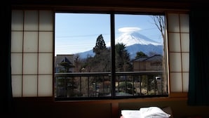 A room with a large window offering a view of a mountain. - Togawaso (Fujikawaguchiko)