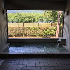 Una habitación con vistas a un jardín, una piscina pequeña y una valla de madera.