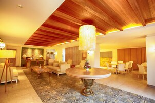 A spacious living area with a round wooden coffee table, a sofa, and a chandelier.