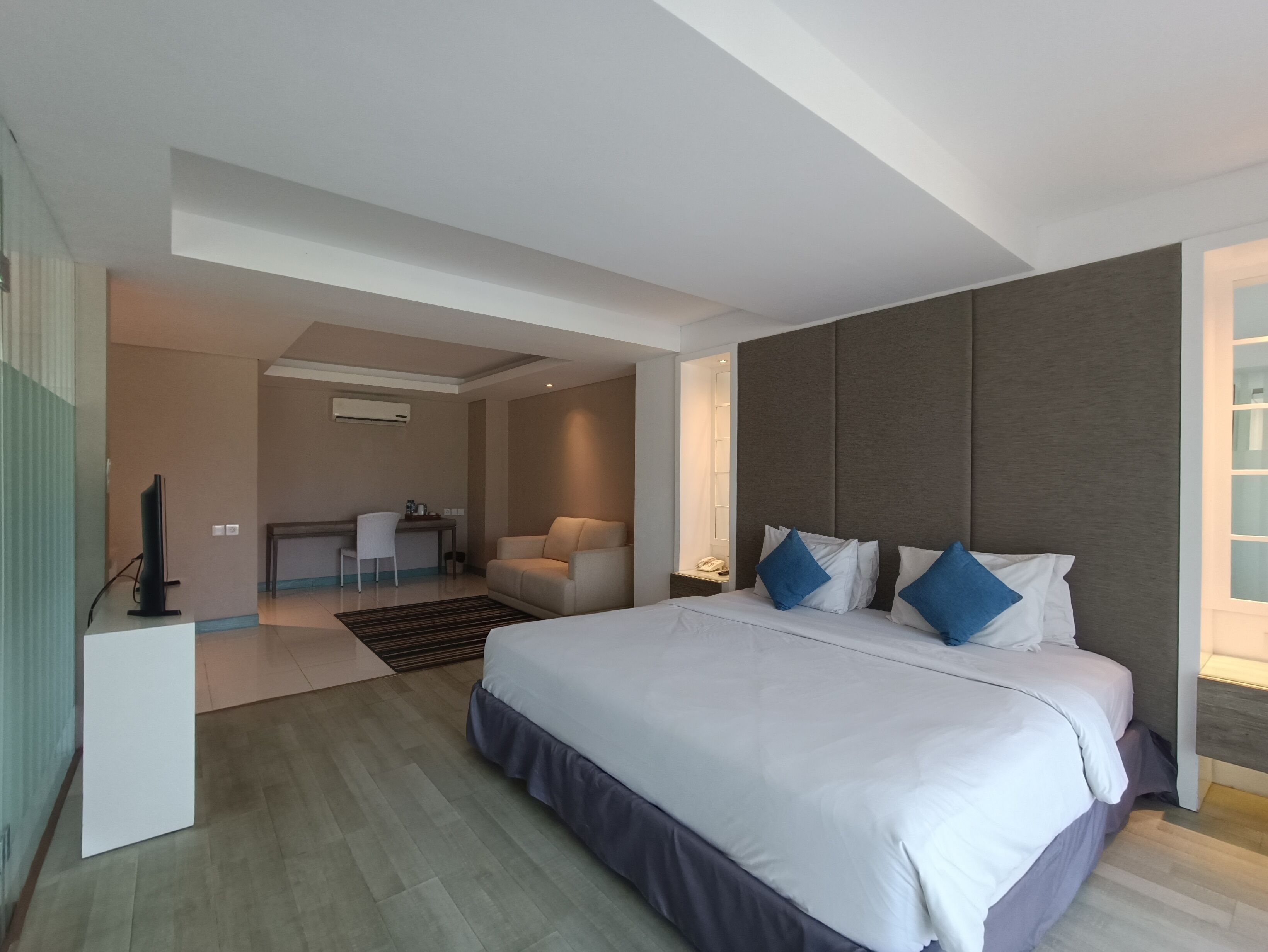 Una habitación de hotel moderna con una cama grande, un escritorio y una silla.