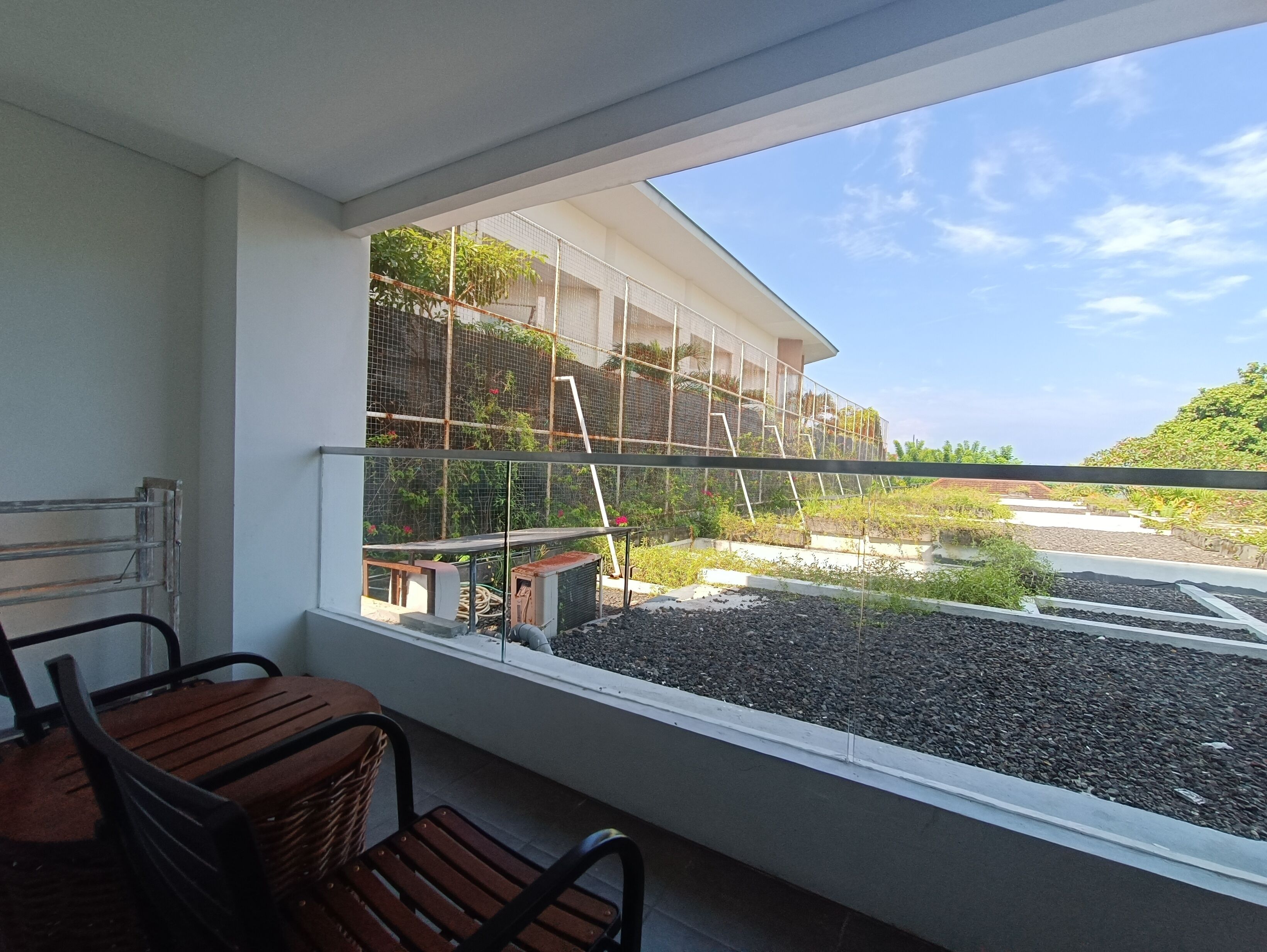 Un balcón con vistas a un jardín y un edificio.