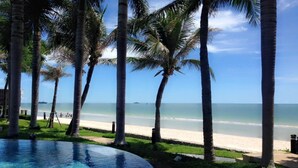 A pool area with a view of the beach and ocean. - Baan San Ploen Condominium by Renvio (Hua Hin)