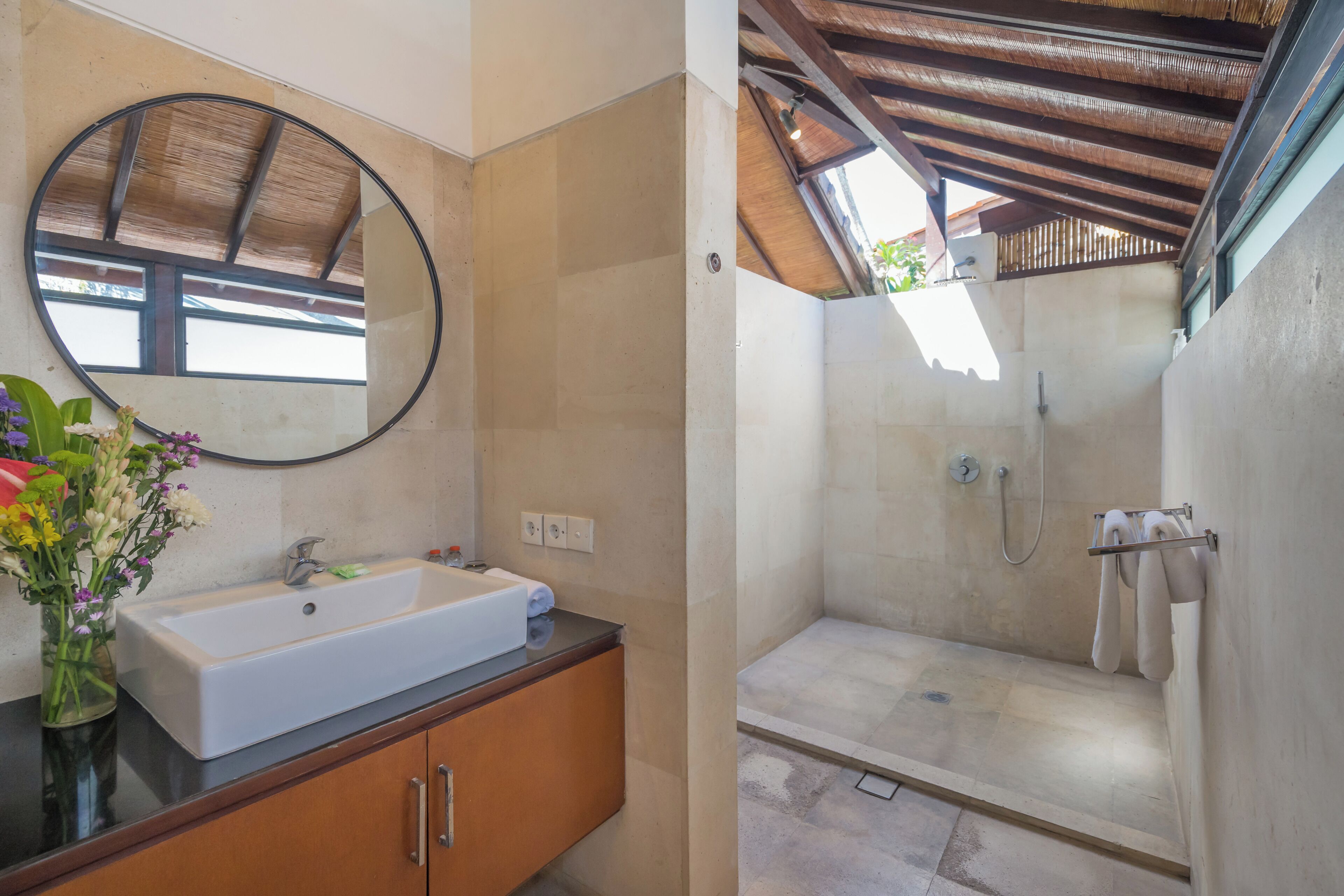 A bathroom with a sink, mirror, and shower.
