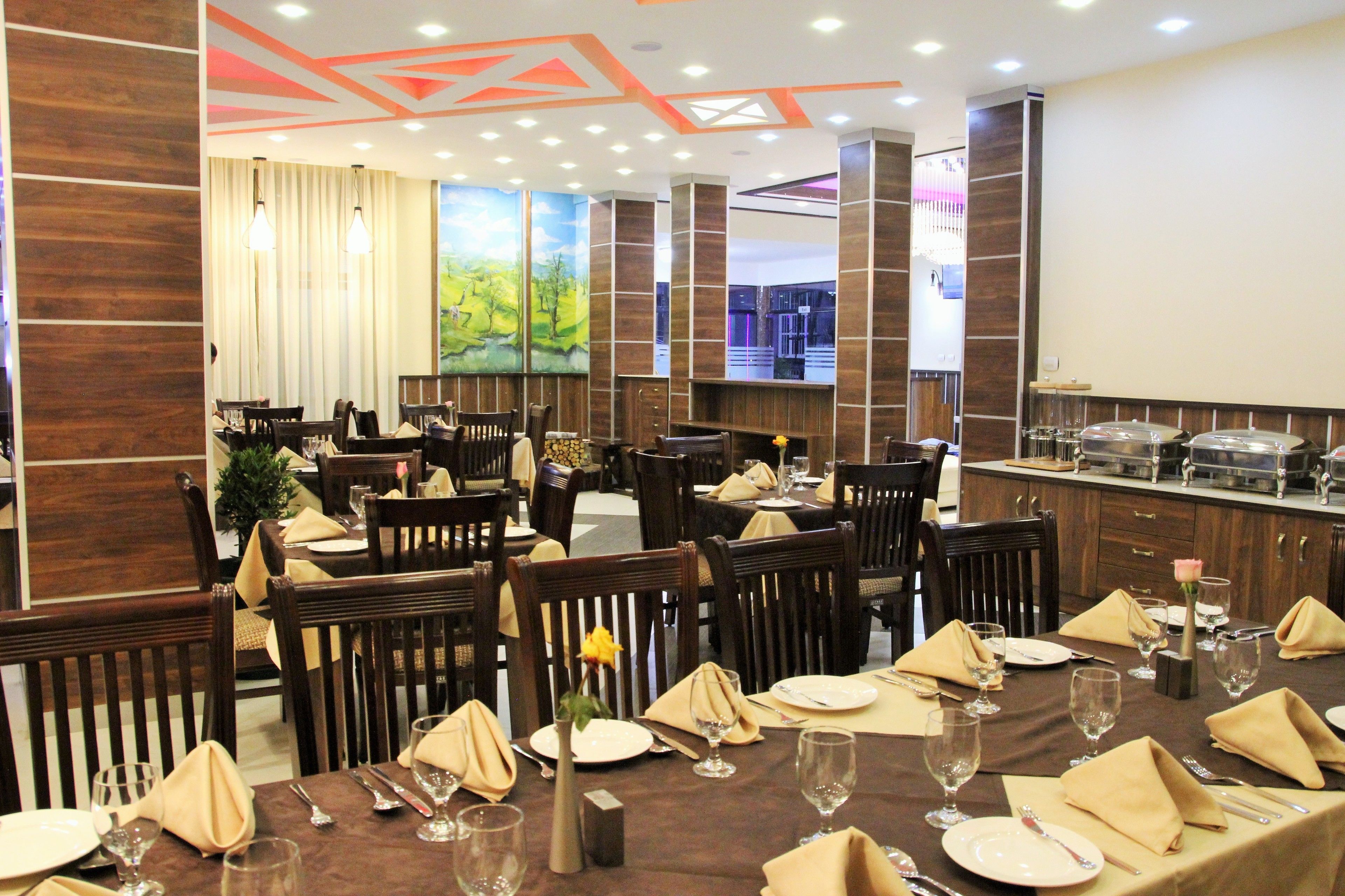 Un restaurante con varias mesas dispuestas con vajilla, sillas y una zona de bar.