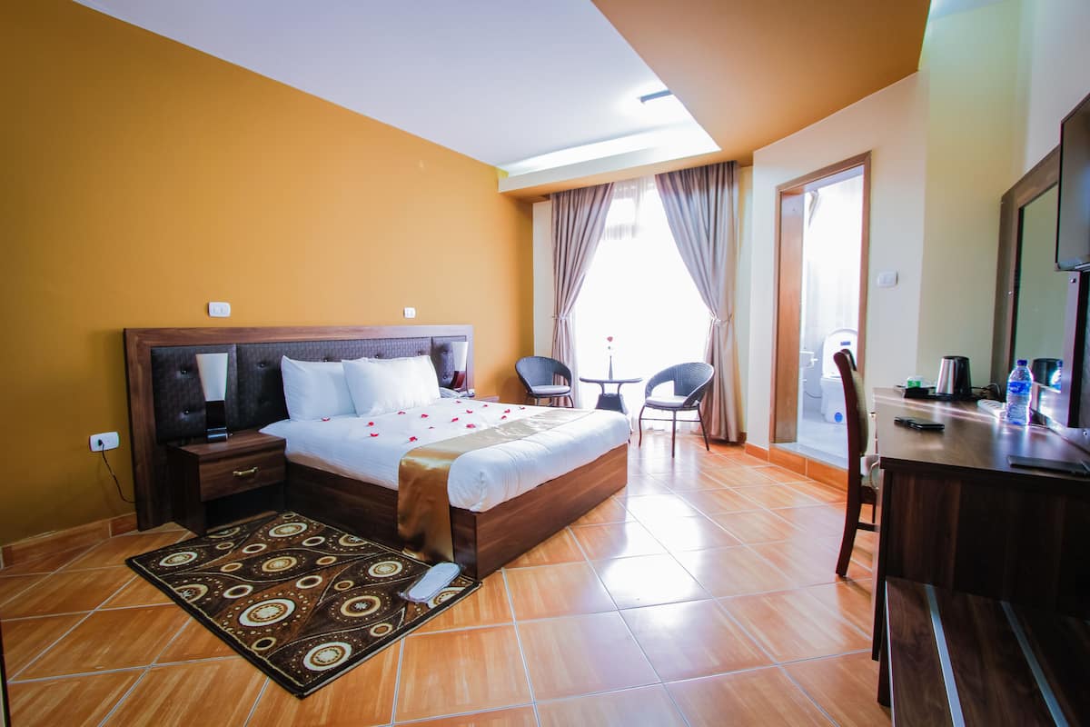 Habitació d'hotel amb un llit gran, un escriptori i una cadira.