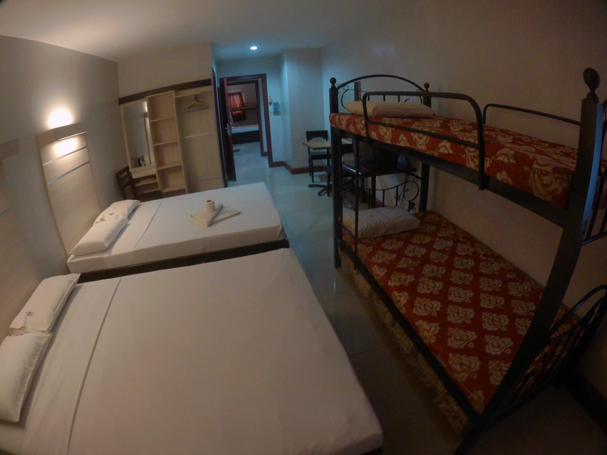 Une chambre de dortoir avec des lits superposés, un bureau et une chaise.