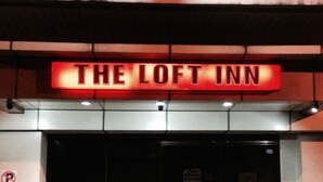 Un letrero para 'The Loft Inn' con un diseño moderno e iluminación.